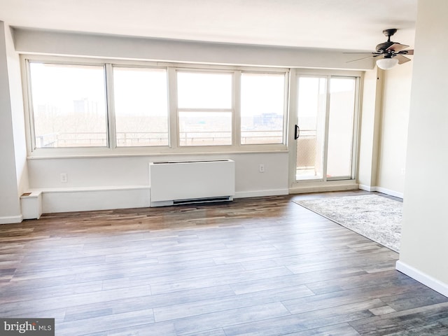 empty room with light hardwood / wood-style floors, a healthy amount of sunlight, and ceiling fan