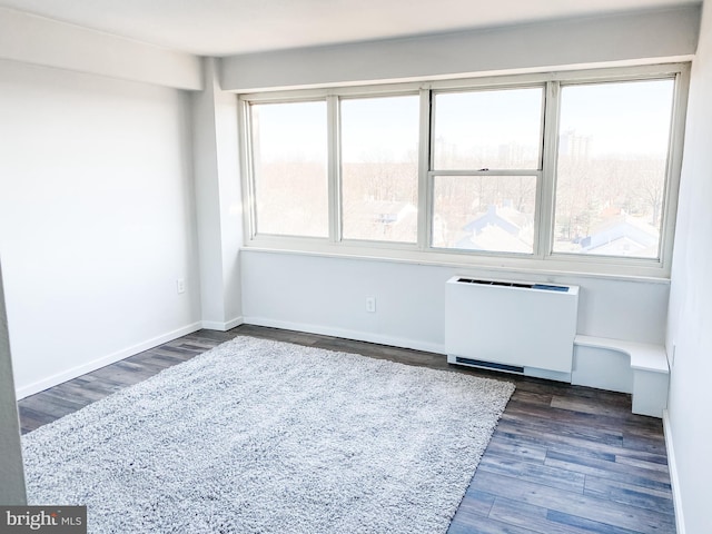 unfurnished room with radiator heating unit and dark wood-type flooring