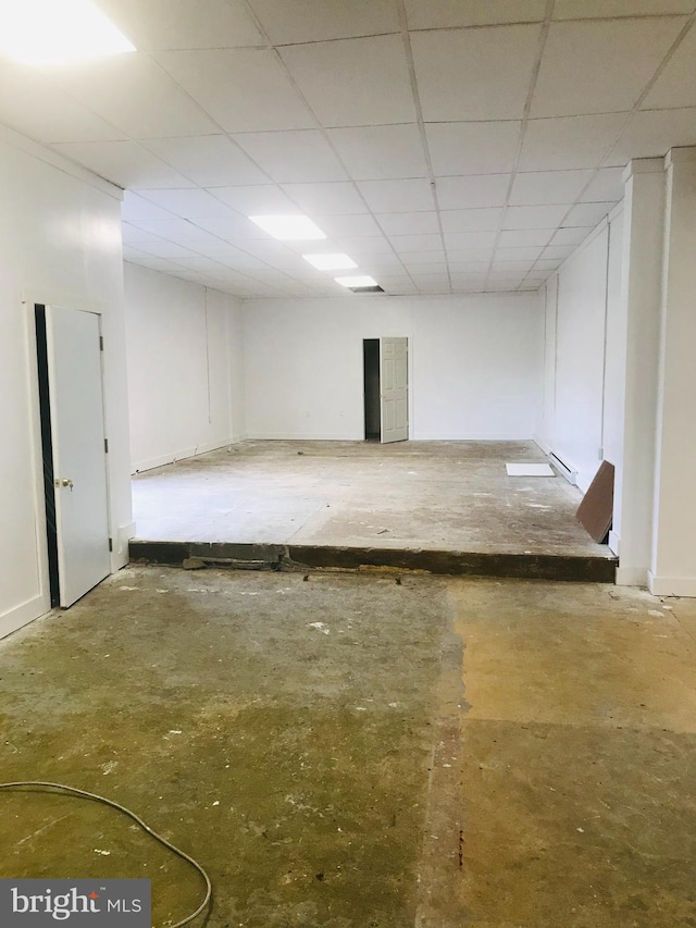 basement featuring a drop ceiling and a baseboard radiator