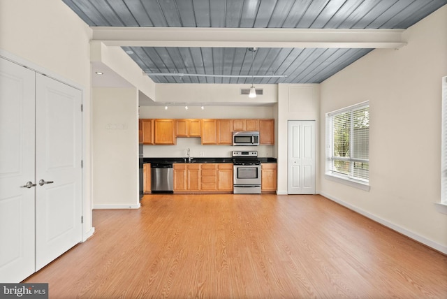 kitchen featuring visible vents, appliances with stainless steel finishes, light wood-style floors, a sink, and beamed ceiling