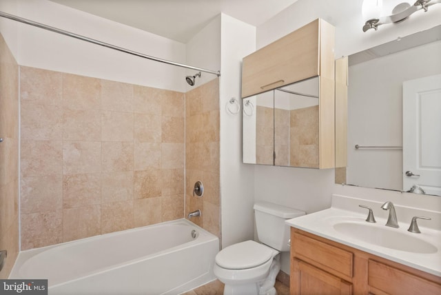 full bathroom with toilet, vanity, and tiled shower / bath