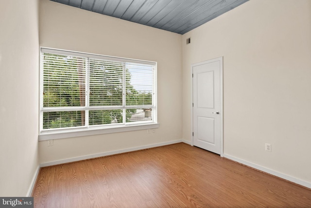 spare room with wooden ceiling, wood finished floors, and baseboards