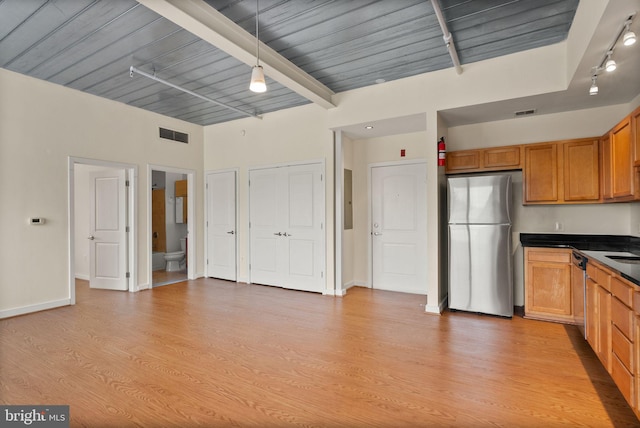 kitchen with visible vents, dark countertops, appliances with stainless steel finishes, light wood-type flooring, and beam ceiling