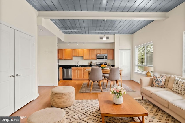 living room with wooden ceiling, visible vents, baseboards, light wood-style floors, and beamed ceiling