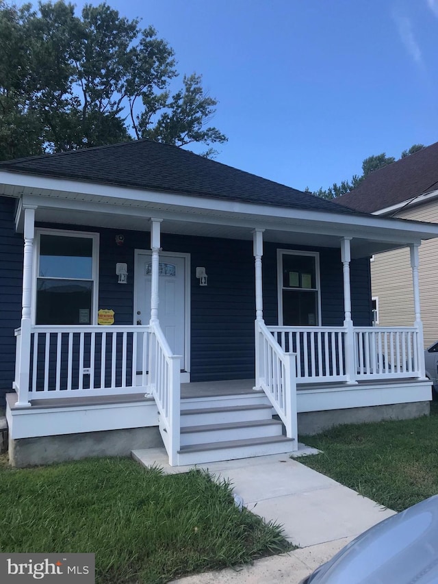 bungalow-style home featuring roof with shingles and a porch