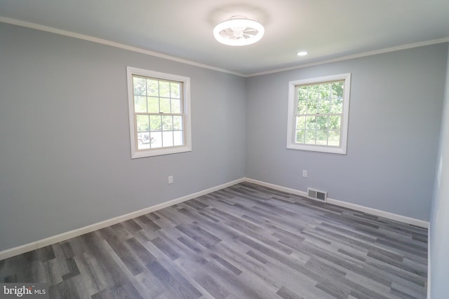 empty room with hardwood / wood-style flooring and ornamental molding