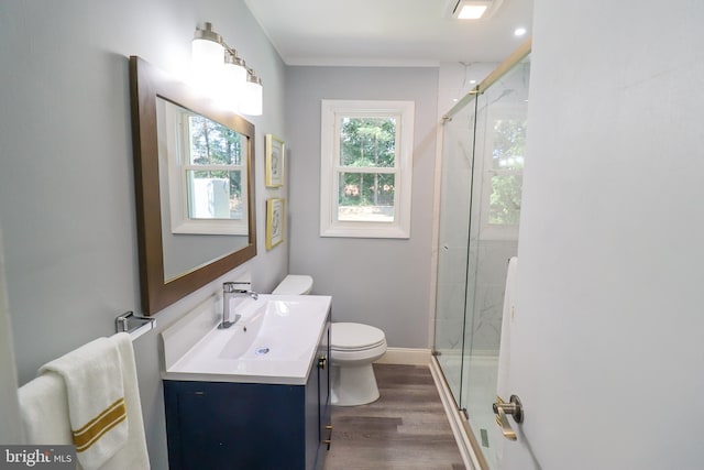 bathroom featuring vanity, toilet, hardwood / wood-style floors, and a shower with door