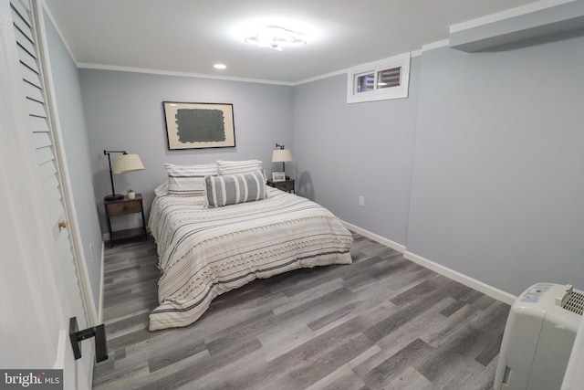 bedroom with crown molding and dark hardwood / wood-style floors