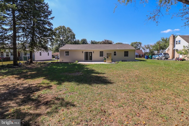 back of property with a lawn and a patio area