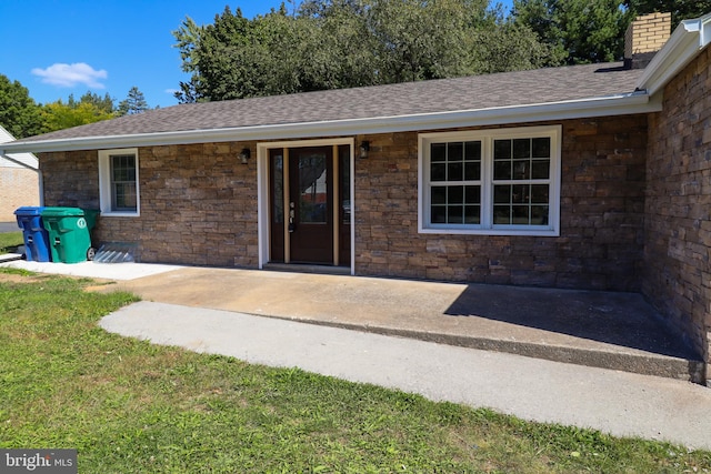 view of exterior entry featuring a lawn