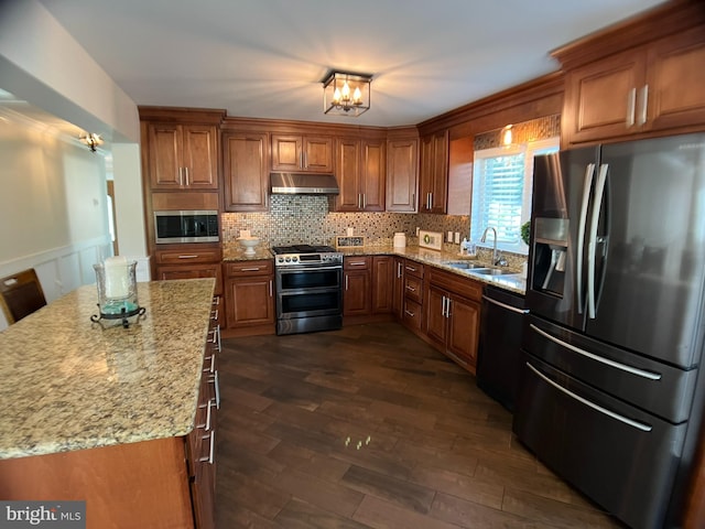 kitchen featuring light stone counters, stainless steel appliances, dark hardwood / wood-style flooring, sink, and decorative backsplash