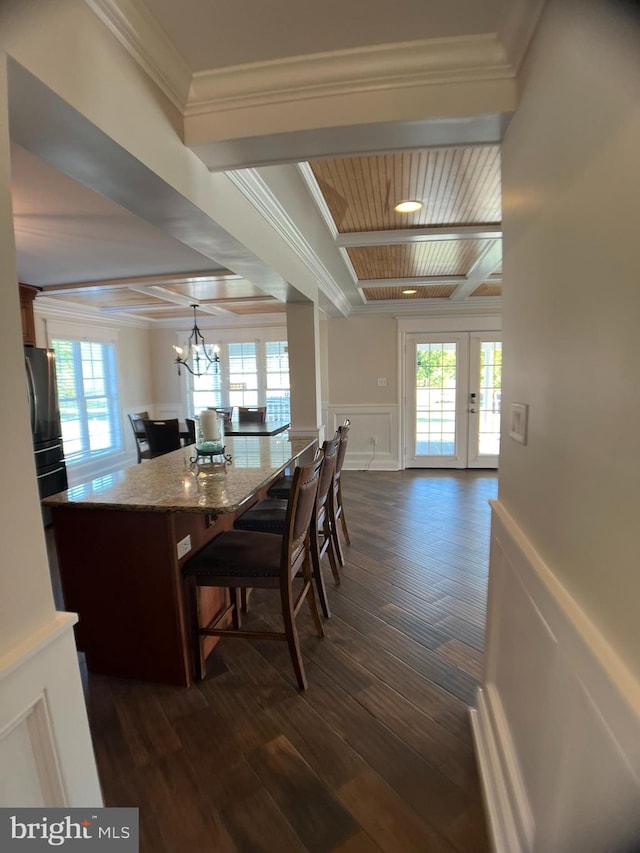 dining area with dark hardwood / wood-style flooring, a notable chandelier, french doors, wood ceiling, and crown molding