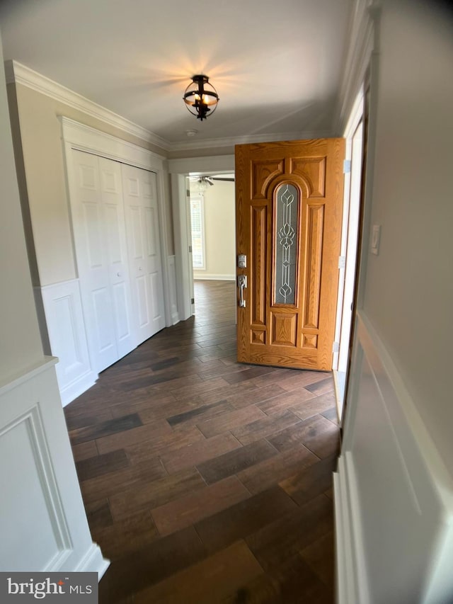 entryway with ornamental molding and dark hardwood / wood-style floors