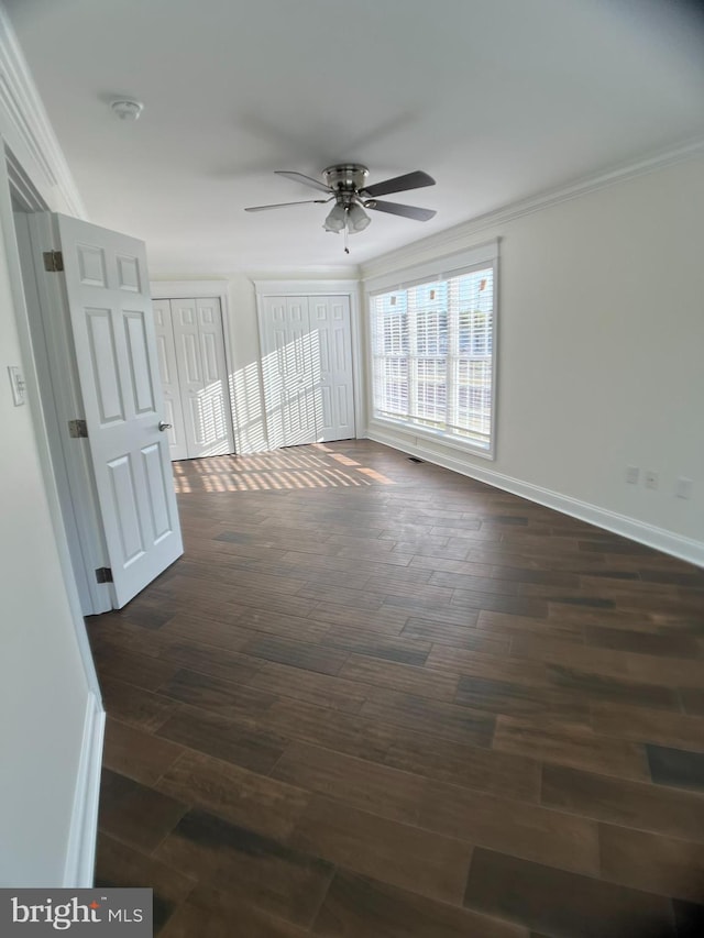 unfurnished room featuring crown molding, dark wood-type flooring, and ceiling fan