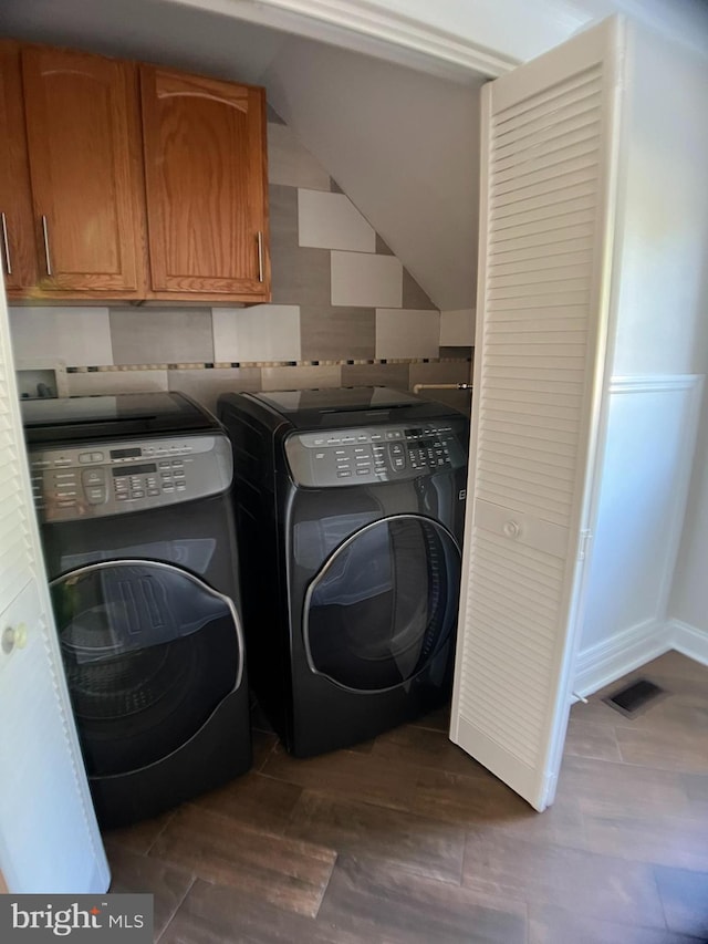 washroom with cabinets, washer and clothes dryer, and dark hardwood / wood-style flooring