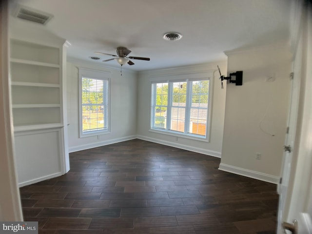 unfurnished room featuring a wealth of natural light, ceiling fan, and dark hardwood / wood-style flooring