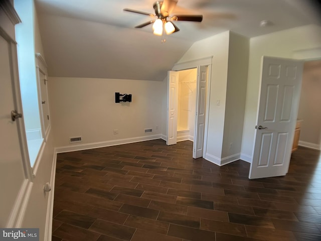 additional living space with ceiling fan, dark hardwood / wood-style flooring, and vaulted ceiling