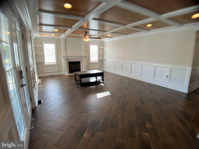 unfurnished living room with dark hardwood / wood-style flooring, beamed ceiling, coffered ceiling, a premium fireplace, and ceiling fan