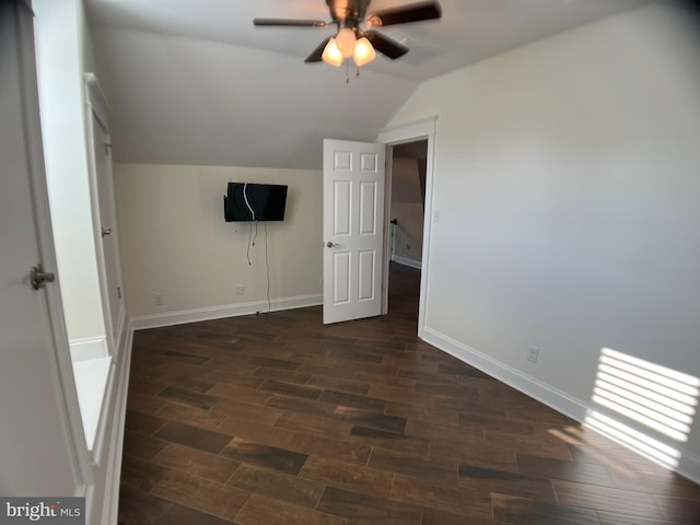 interior space with dark wood-type flooring, vaulted ceiling, and ceiling fan