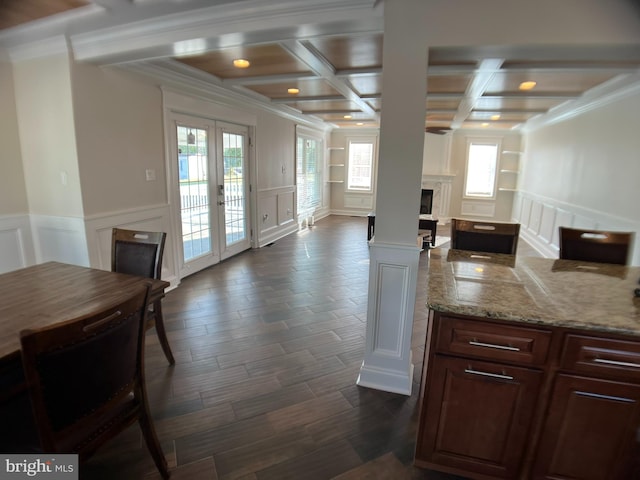 kitchen with coffered ceiling, crown molding, light stone counters, dark wood-type flooring, and beam ceiling