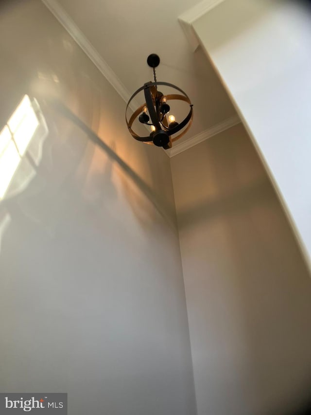 room details featuring crown molding and an inviting chandelier