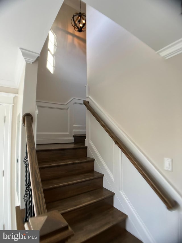 staircase with a notable chandelier