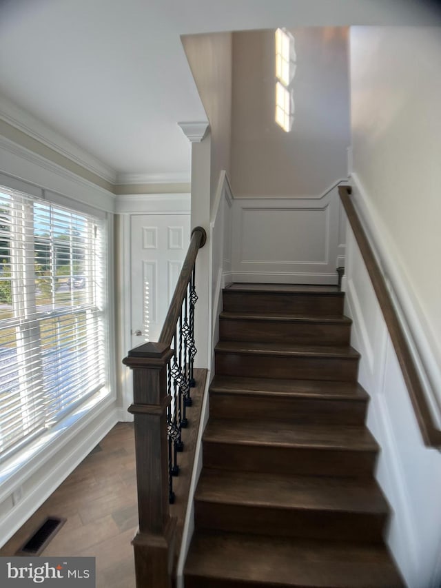 stairway featuring crown molding and hardwood / wood-style flooring