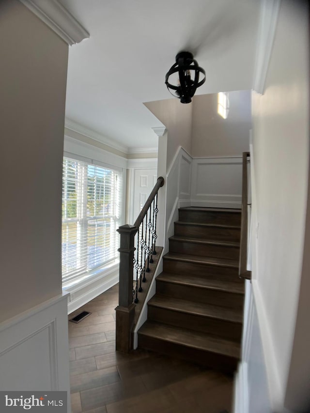 stairway featuring ornamental molding and hardwood / wood-style floors