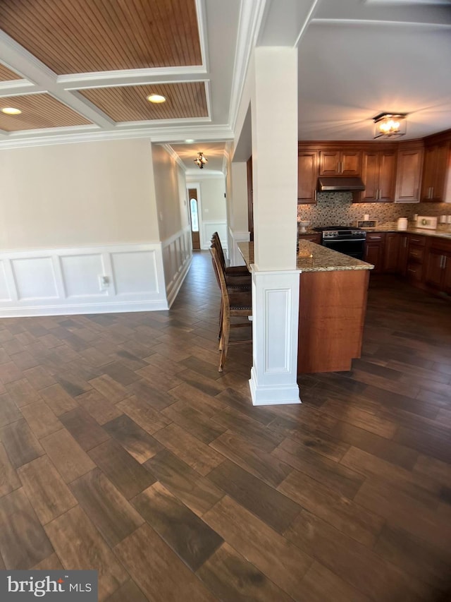 kitchen featuring kitchen peninsula, stainless steel range, dark hardwood / wood-style flooring, and crown molding