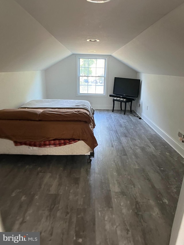 unfurnished bedroom featuring vaulted ceiling and dark hardwood / wood-style floors