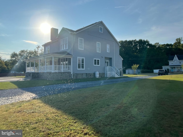 view of side of home featuring a yard and a porch