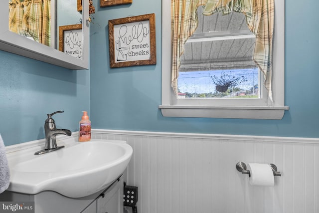 bathroom with a wainscoted wall and vanity