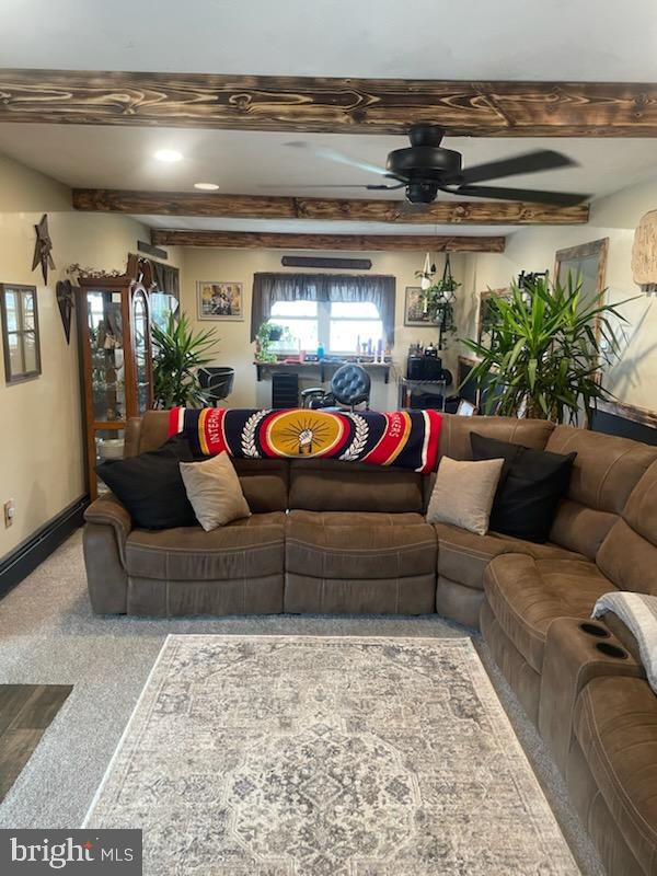 living room with beam ceiling, ceiling fan, and baseboards