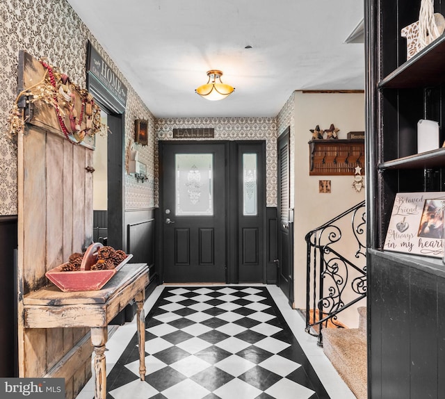 foyer featuring tile patterned floors, visible vents, and a wainscoted wall