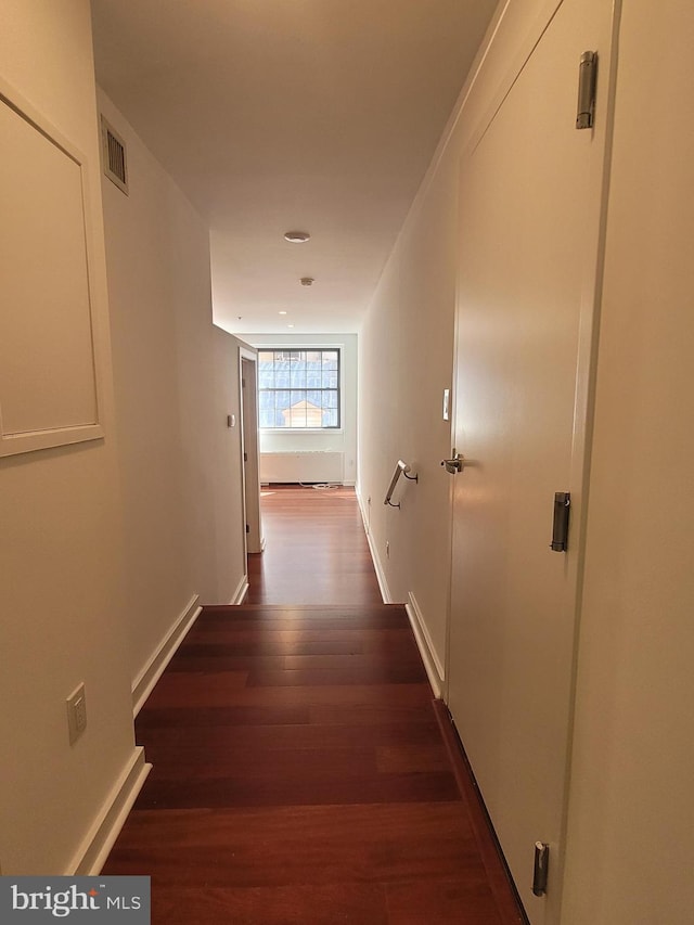 corridor featuring baseboards, visible vents, and dark wood-style flooring