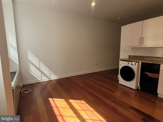 clothes washing area featuring laundry area, baseboards, washer / clothes dryer, and dark wood-style flooring