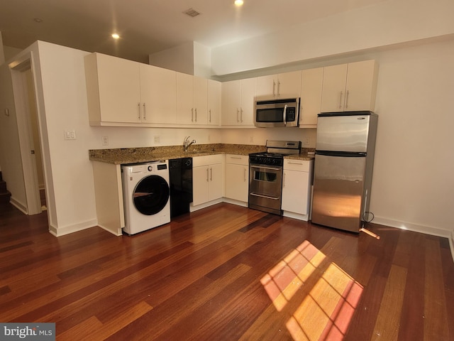 kitchen featuring stainless steel appliances, washer / clothes dryer, white cabinetry, and dark wood-style floors