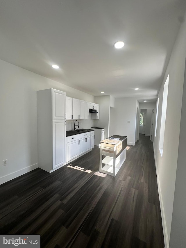 kitchen with sink, white cabinetry, and dark hardwood / wood-style floors