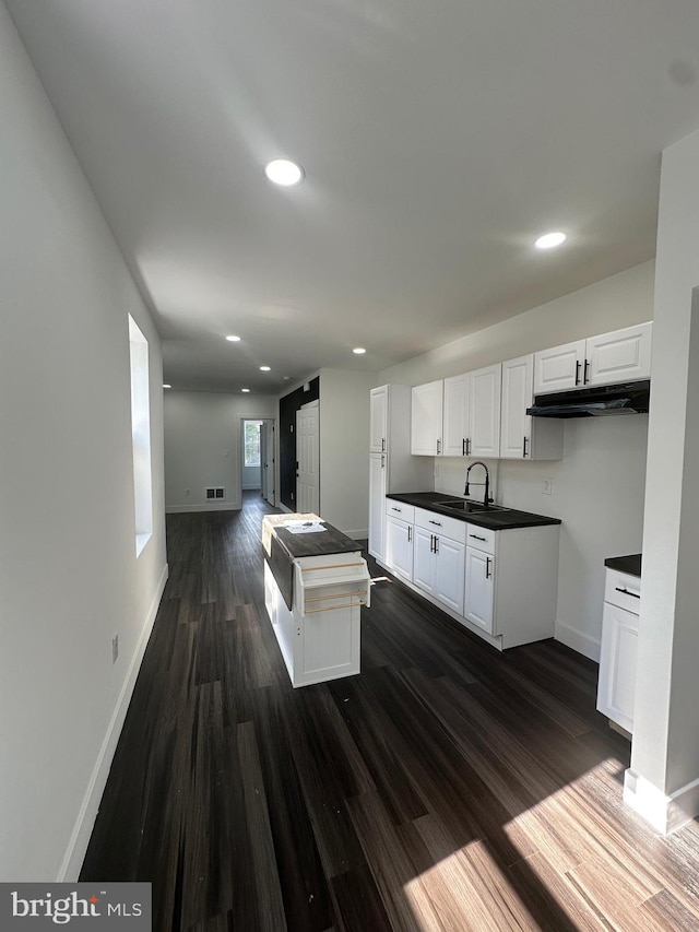 kitchen with sink, white cabinets, and dark hardwood / wood-style flooring