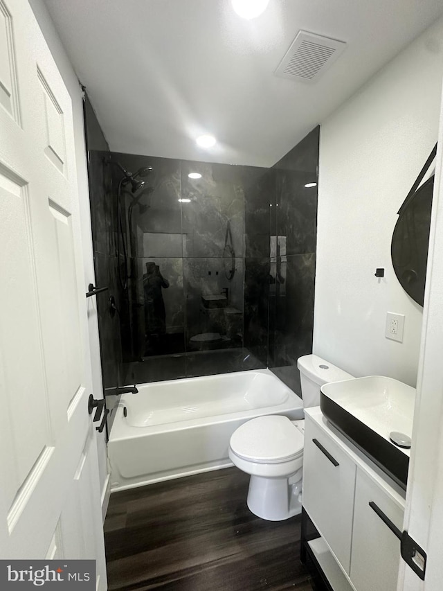 full bathroom with vanity, toilet, tiled shower / bath combo, and wood-type flooring