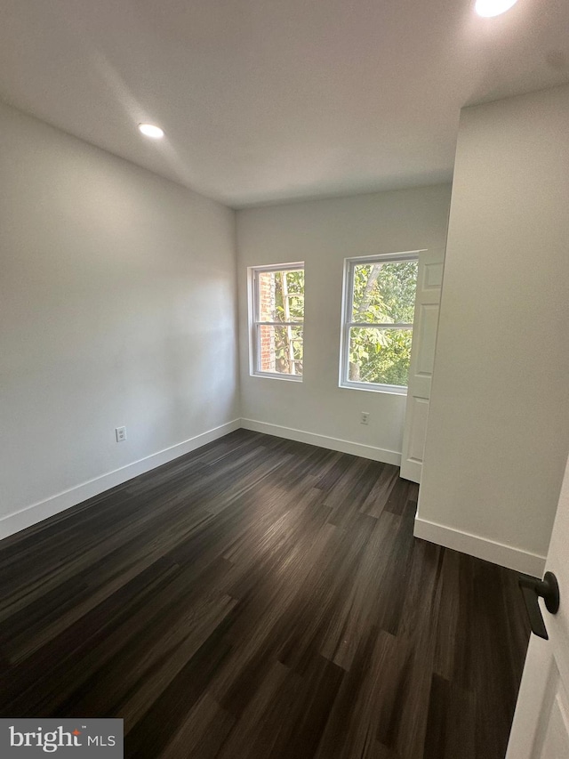 spare room featuring dark wood-type flooring