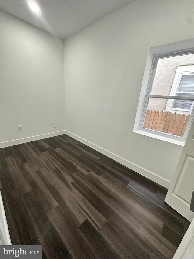 unfurnished room featuring dark wood-type flooring