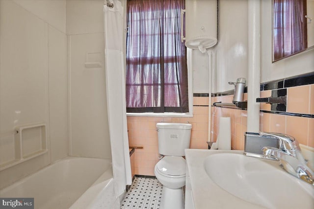 bathroom featuring tile walls, toilet, water heater, and tile patterned flooring