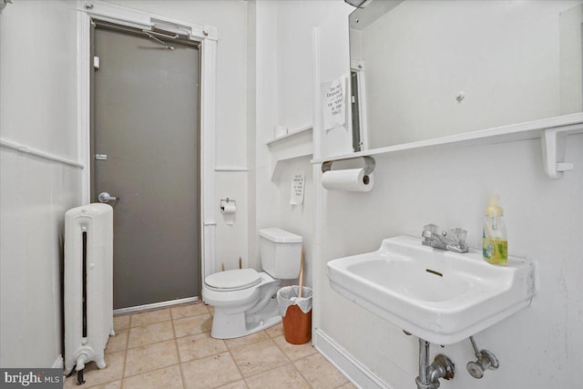 bathroom with sink, toilet, radiator heating unit, and tile patterned floors