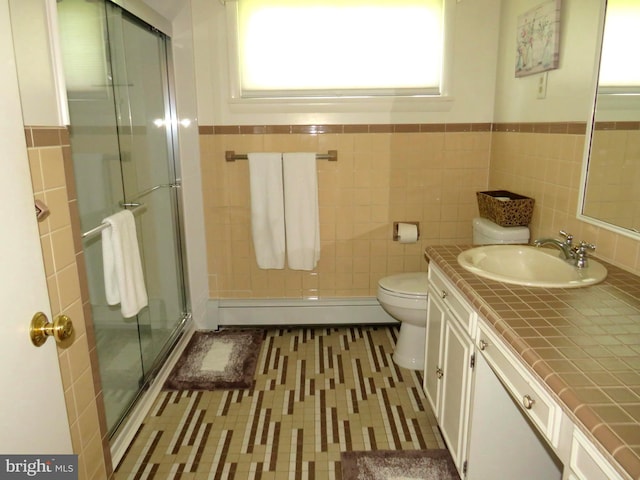 bathroom featuring vanity, toilet, an enclosed shower, and tile walls