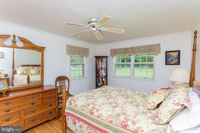 bedroom featuring ceiling fan, light hardwood / wood-style floors, and ornamental molding