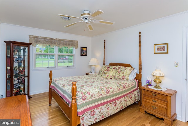 bedroom with ceiling fan, light hardwood / wood-style floors, and crown molding