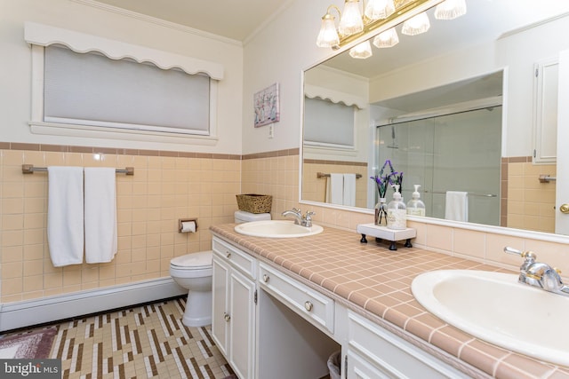 bathroom featuring toilet, vanity, a baseboard heating unit, tile walls, and a shower with shower door