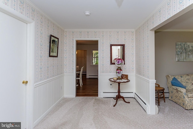 hall featuring a baseboard heating unit, ornamental molding, and hardwood / wood-style flooring