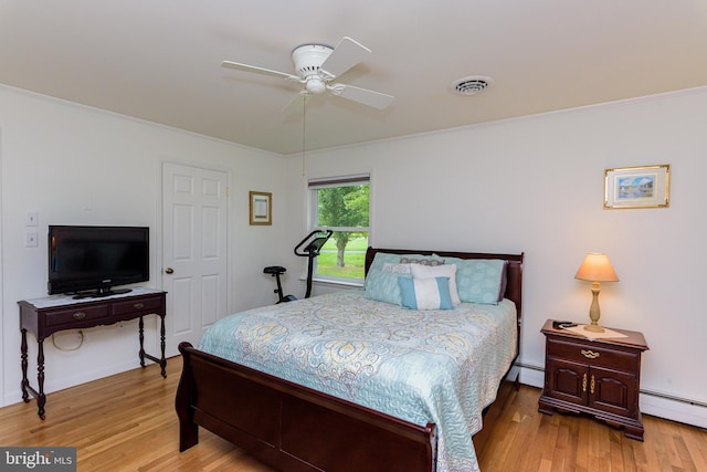 bedroom featuring crown molding, wood-type flooring, a baseboard radiator, and ceiling fan